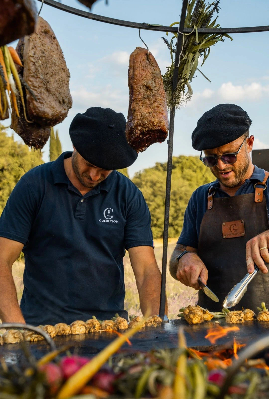 Membres de Tournebroche Gueuleton au brasero dans le domaine Terre Ugo pour la soirée "Les Banquets d'été". 