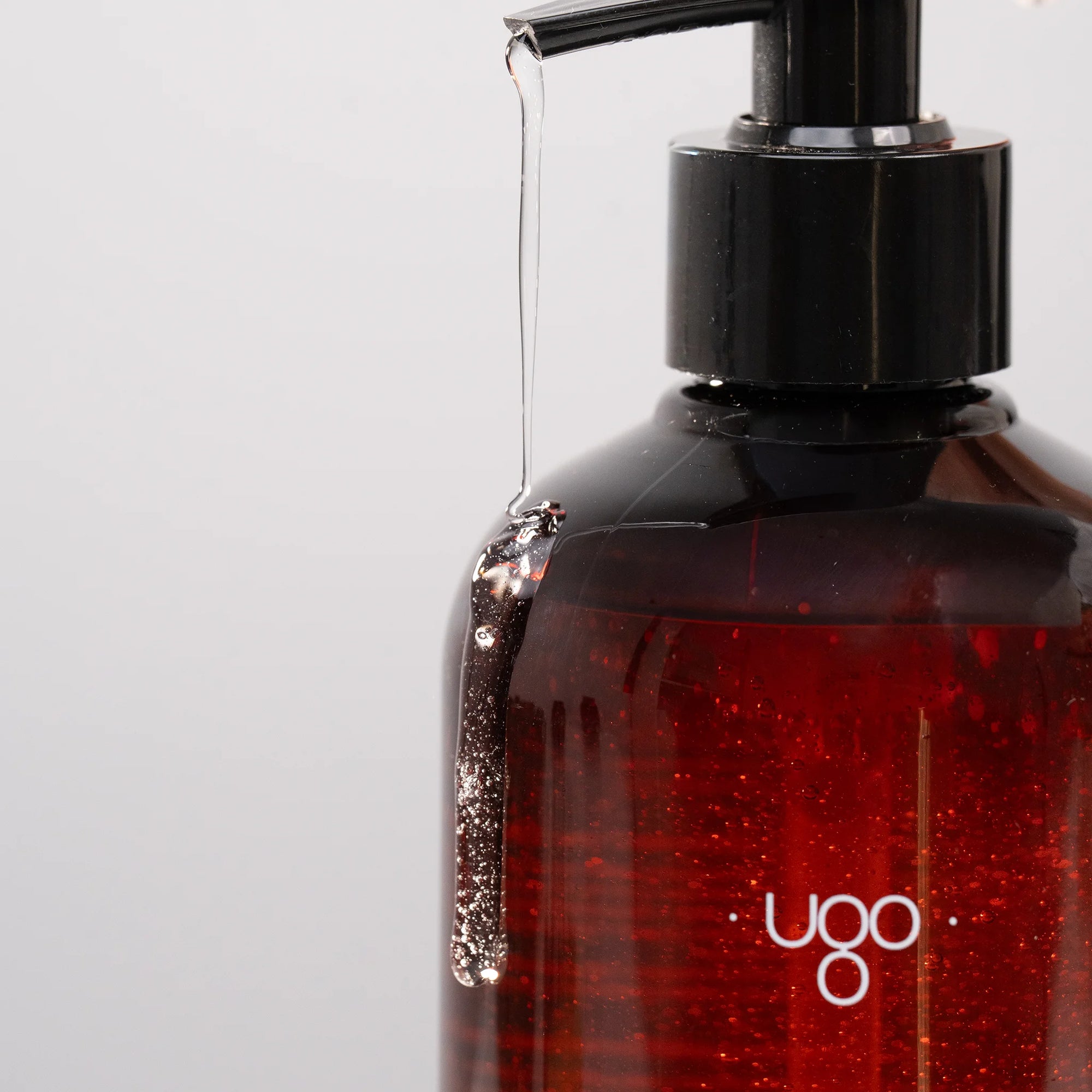 Fluide lavant Terre Ugo en flacon ambré, vue en angle sur fond clair.