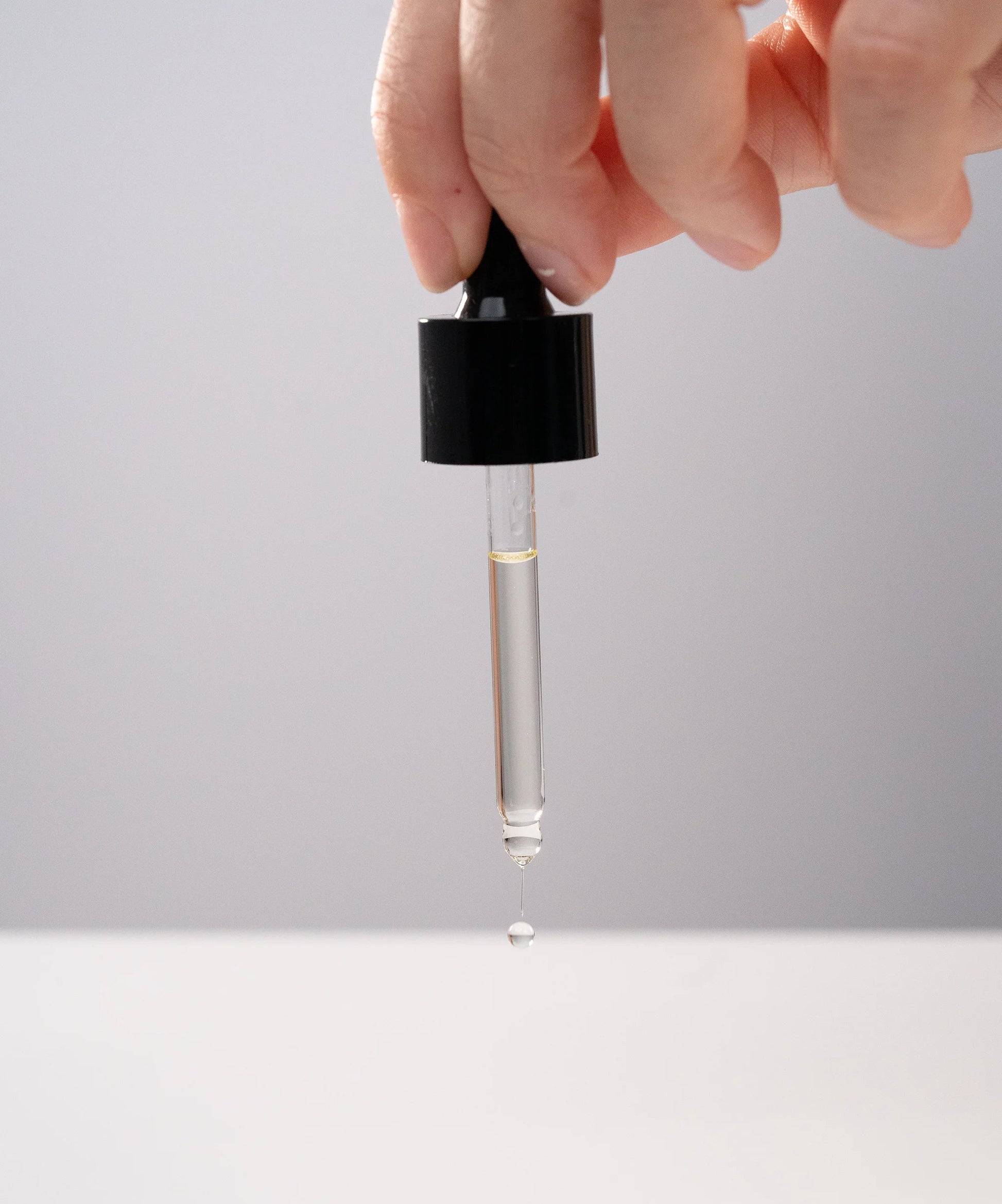 Huile de massage Terre Ugo avec pipette laissant tomber une goutte, vue lifestyle.