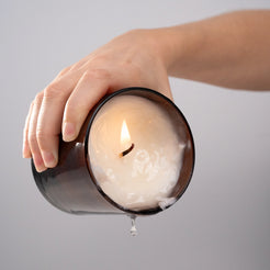 Bougie parfumée Terre Ugo vue du dessus, tenue à la main.